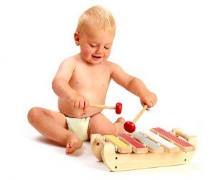 a cute baby boy playing a xylophone musical instrument isolated on a white background
